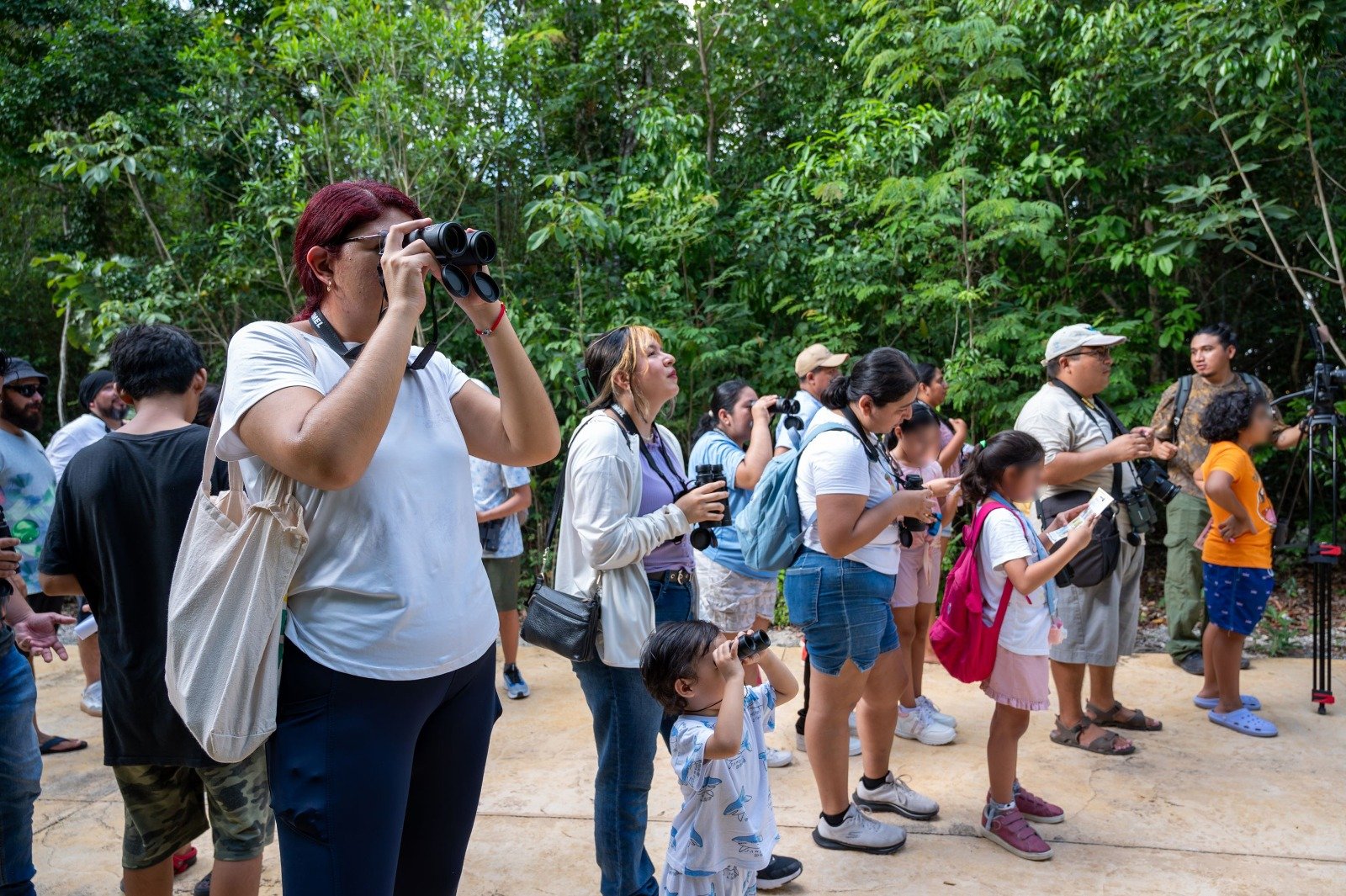 Residents use binoculars to spot birds at Parque Urbano Corazón in Cozumel.