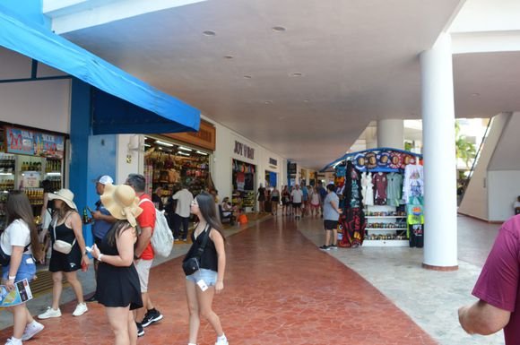 Tourists walk past shops in Cozumel, Quintana Roo, as local business owners report flat sales despite high visitor numbers.