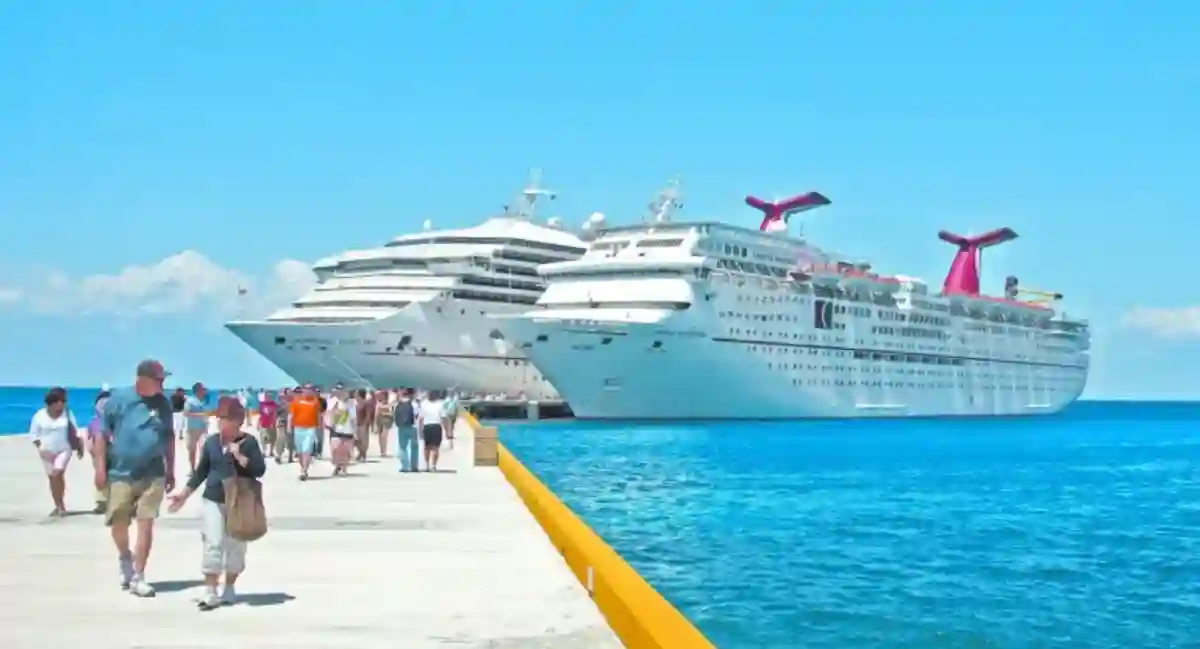 Cruise ship docked at Cozumel port as sargassum accumulates on nearby beaches.
