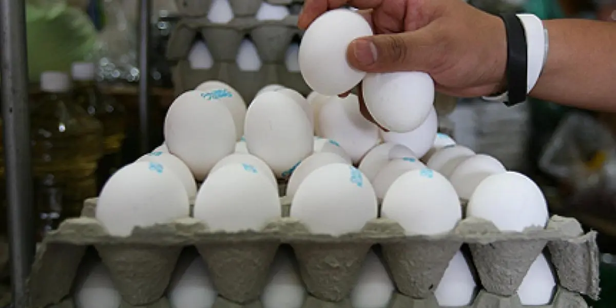 Eggs for sale at a market stall in Mexico, with price tags showing a recent increase