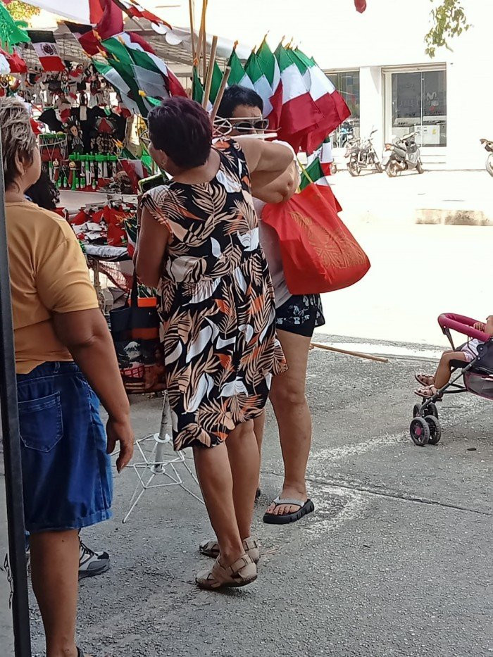 An elderly woman receives medical attention after a metal rod from a street vendor's stall pierced her arm in Cancún, Quintana Roo.