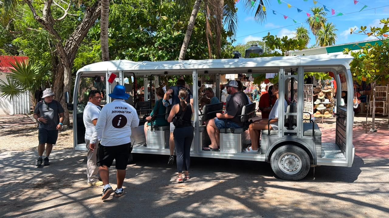 Visitors ride electric carts from the main entrance toward the Tulum archaeological zone.