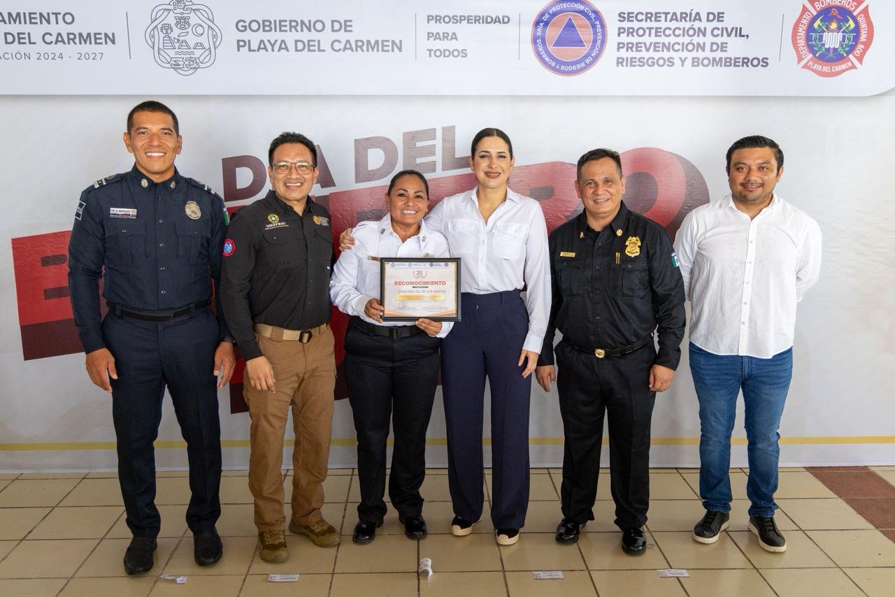 Mayor Estefanía Mercado presents recognition awards to Playa del Carmen firefighters during the National Firefighter Day ceremony.