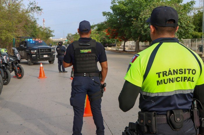 Police officers from Playa del Carmen conduct a GAMA operation traffic checkpoint on a motorcycle.