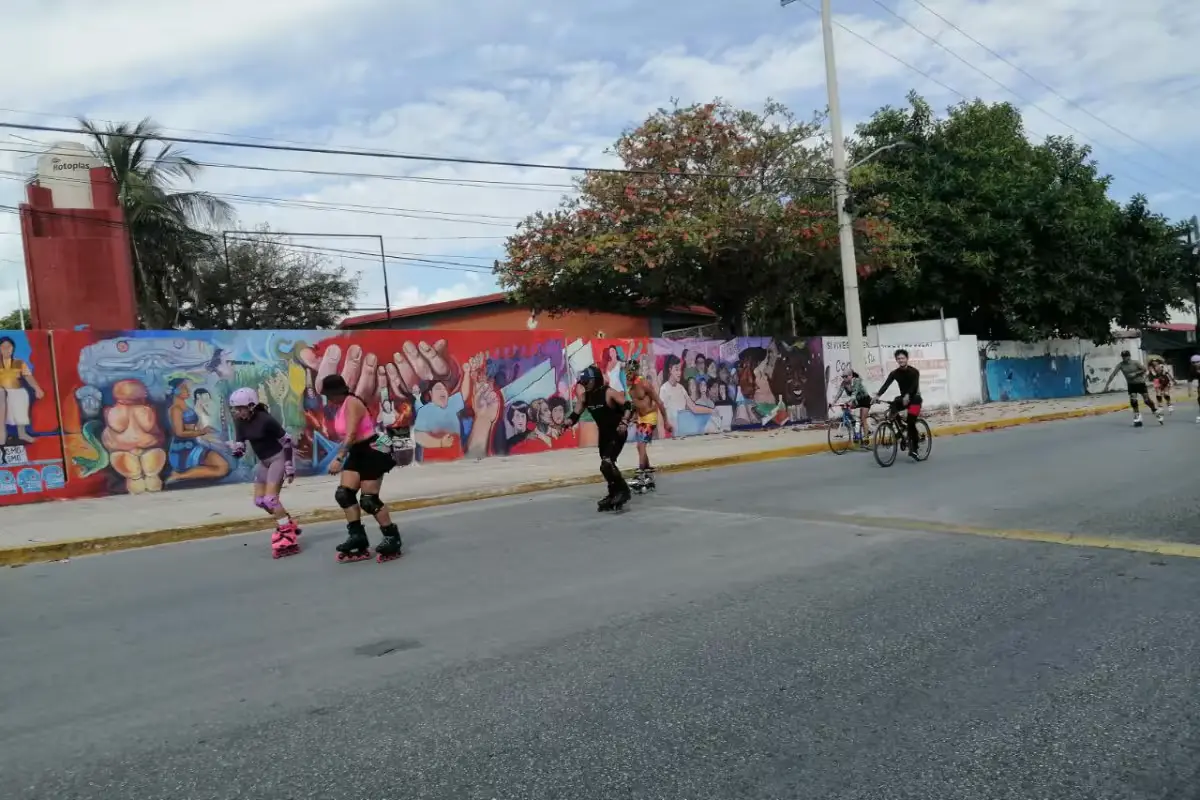 Tourists on bicycles ride through traffic in Isla Mujeres without a dedicated cycle lane