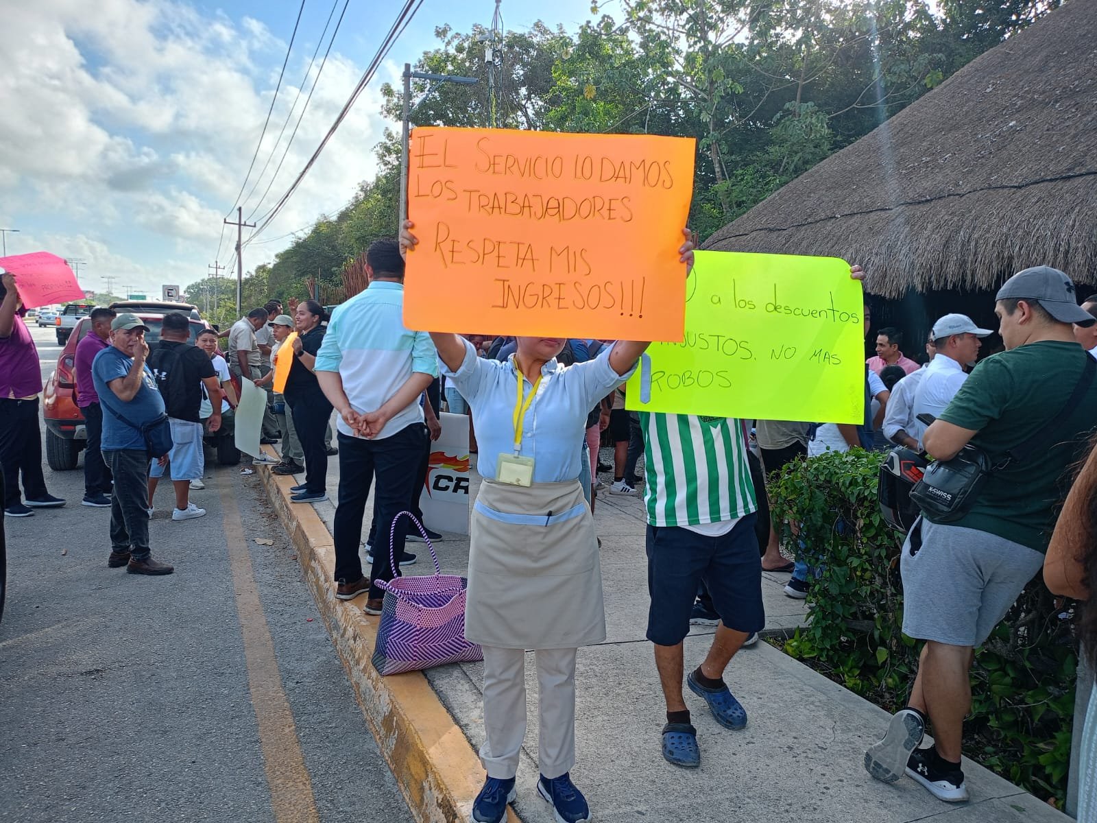 Protesting workers hold signs outside the Mayakoba resort complex in Playa del Carmen, Quintana Roo