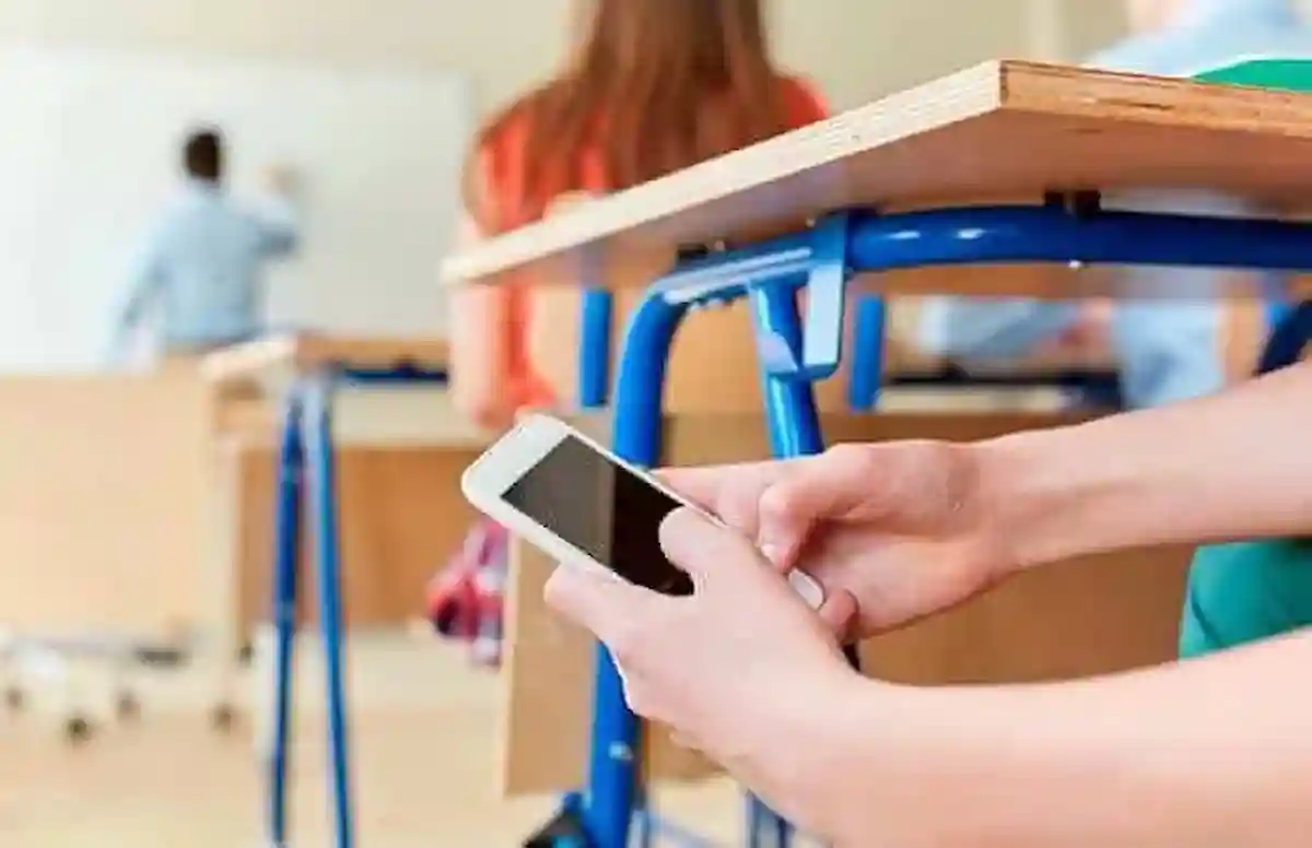 Students using cellphones at a school in Mexico, as the SEP considers age-based regulations for digital device use.