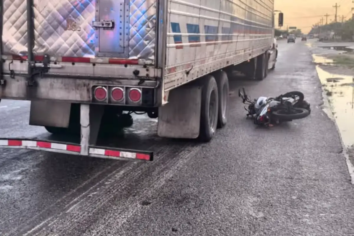A motorcycle lies under the trailer of a heavy vehicle after a fatal accident on Playa del Carmen Boulevard.