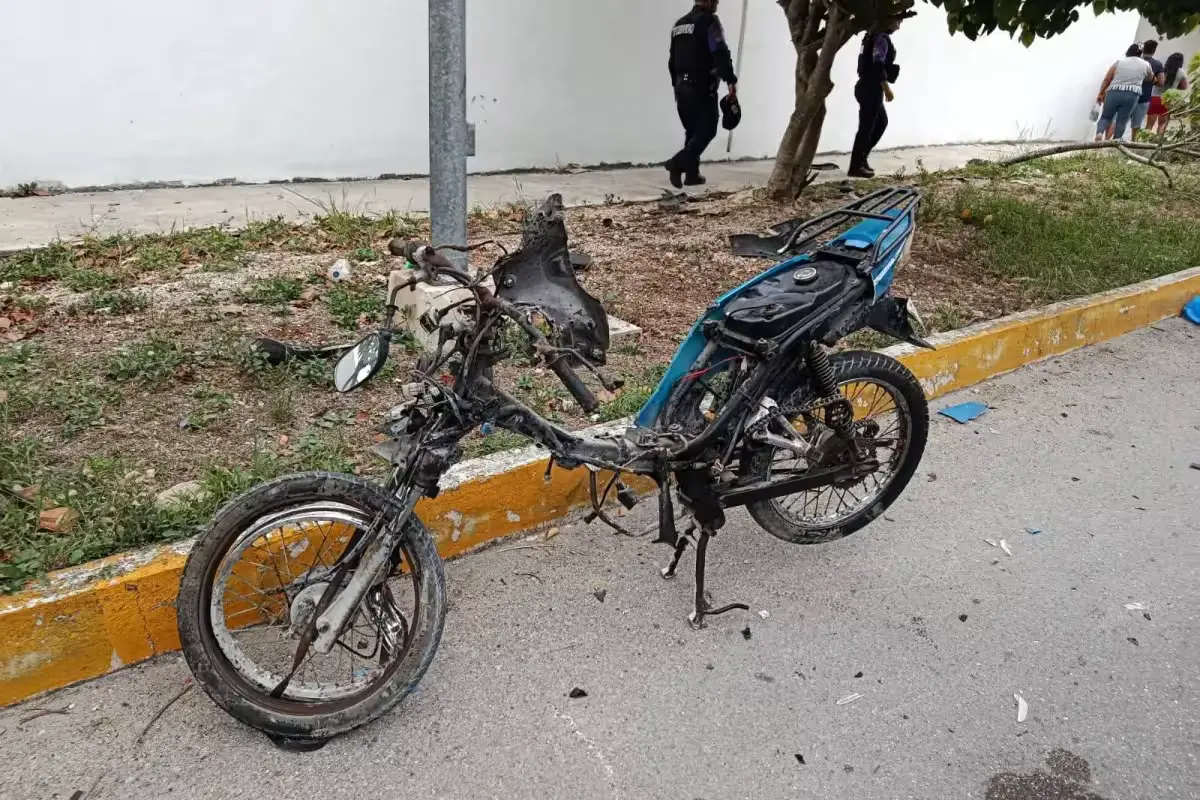 A damaged motorcycle sits at the scene of a fatal crash in Playa del Carmen