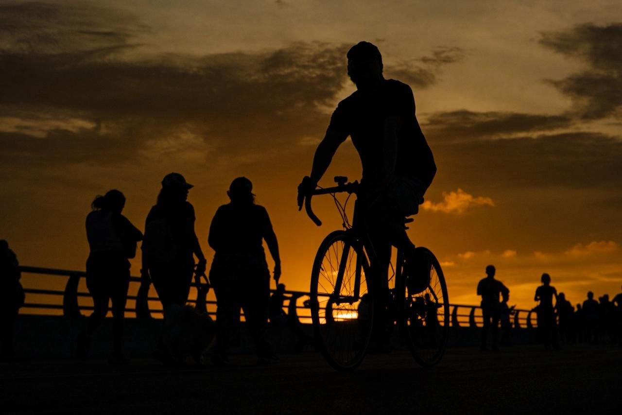 People cycle and walk along the Nichupté Bridge during a family event in Cancún.