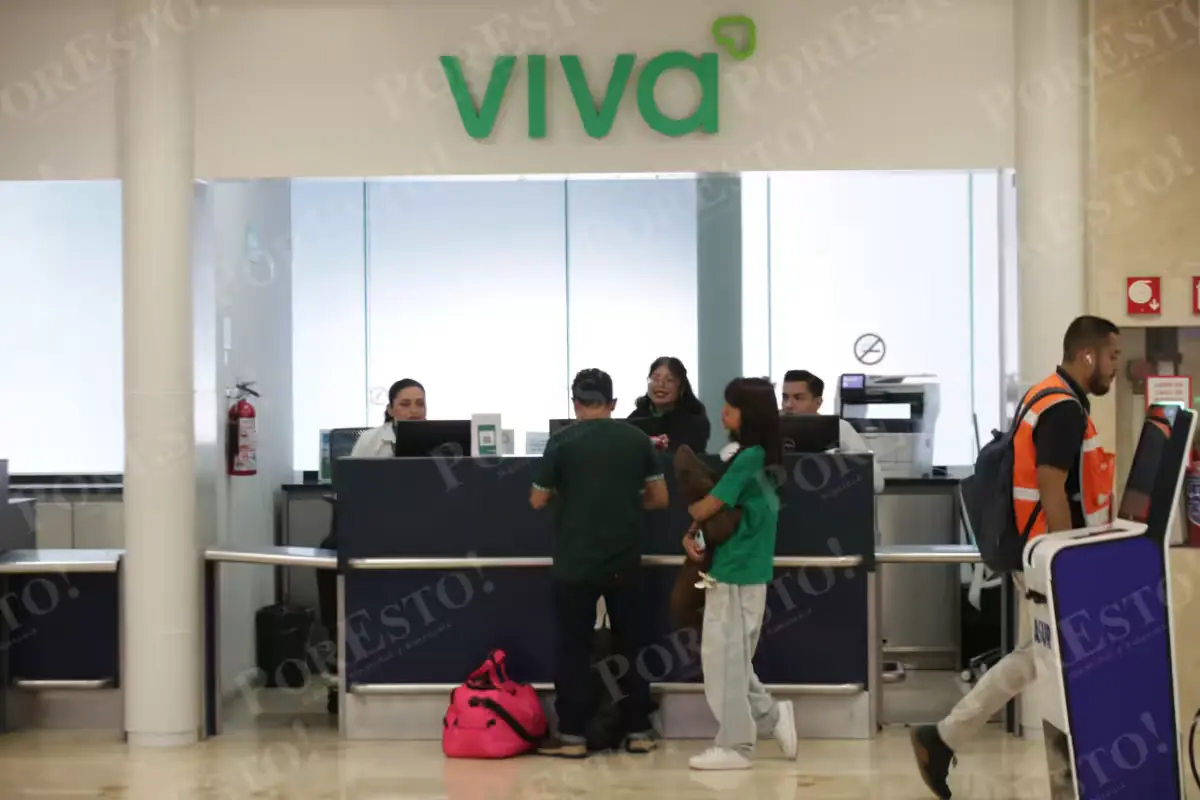 Passengers with luggage walk through Terminal 2 of Cancun International Airport.