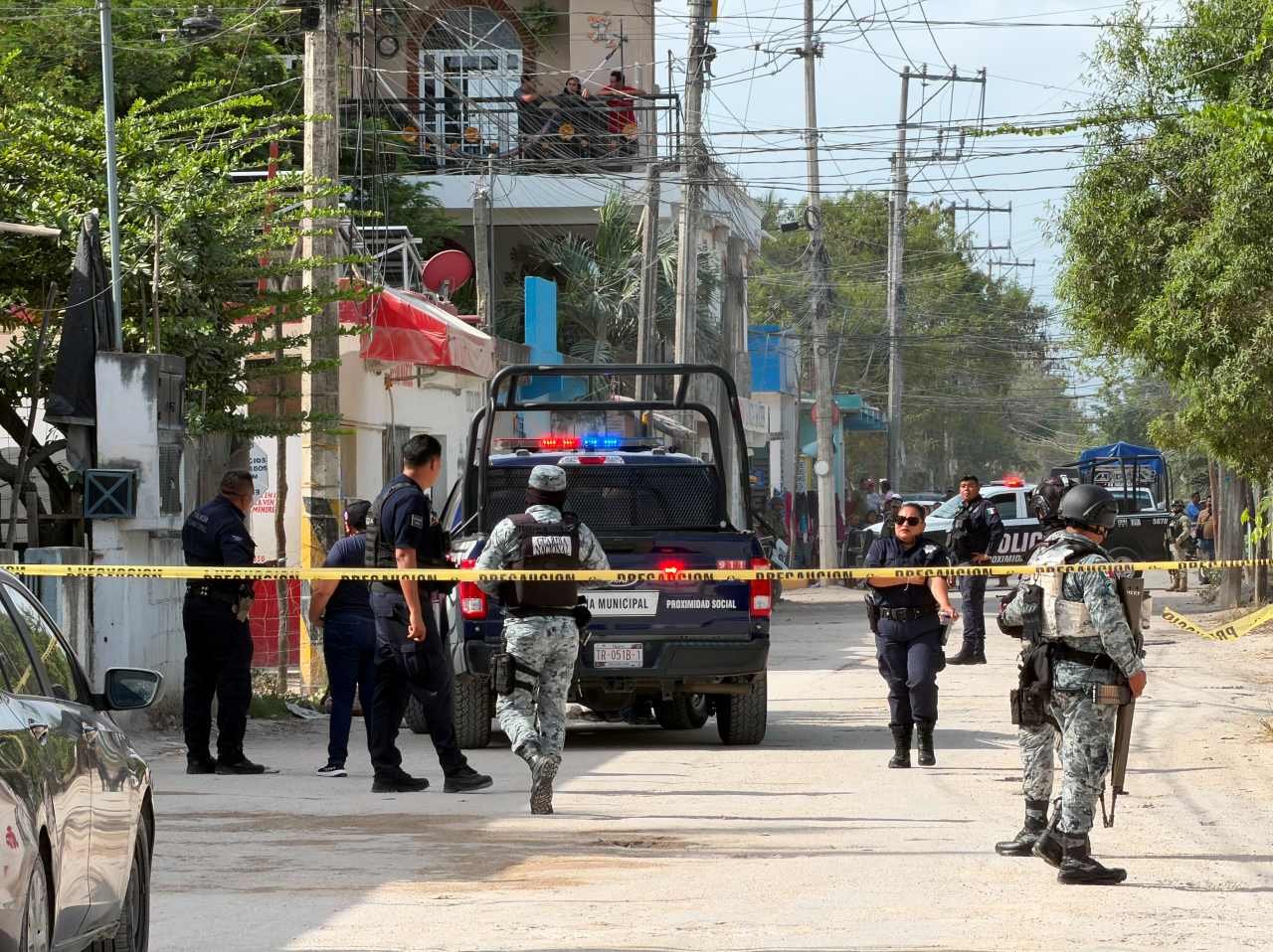 Police and forensic investigators at the scene of a fatal shooting in Cancún's Valle Verde neighborhood.