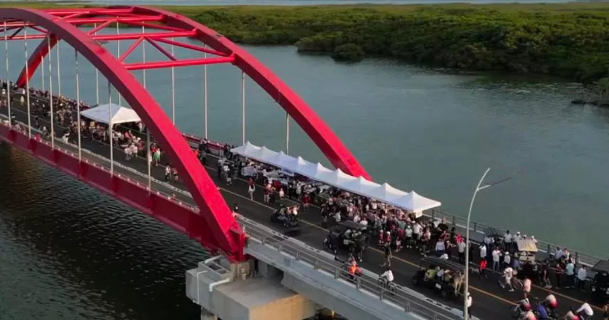People walking and cycling on the Puente Nichupté during the PuenteAndo event in Cancún, Quintana Roo