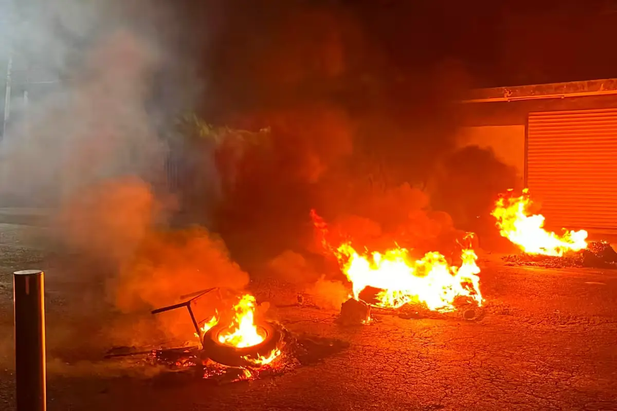 Residents of Cancún's Region 232 block Rancho Viejo Avenue with burning debris to protest a power outage.