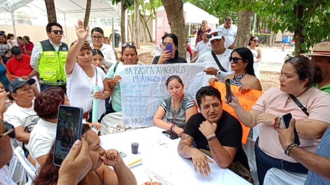 Residents holding signs during a protest at a public audience with Governor Mara Lezama in Playa del Carmen, Quintana Roo.