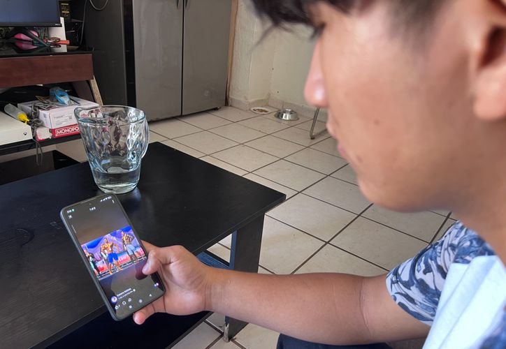 A teenage girl looking at her smartphone while scrolling through social media apps, illustrating the impact of excessive social media use on adolescents.