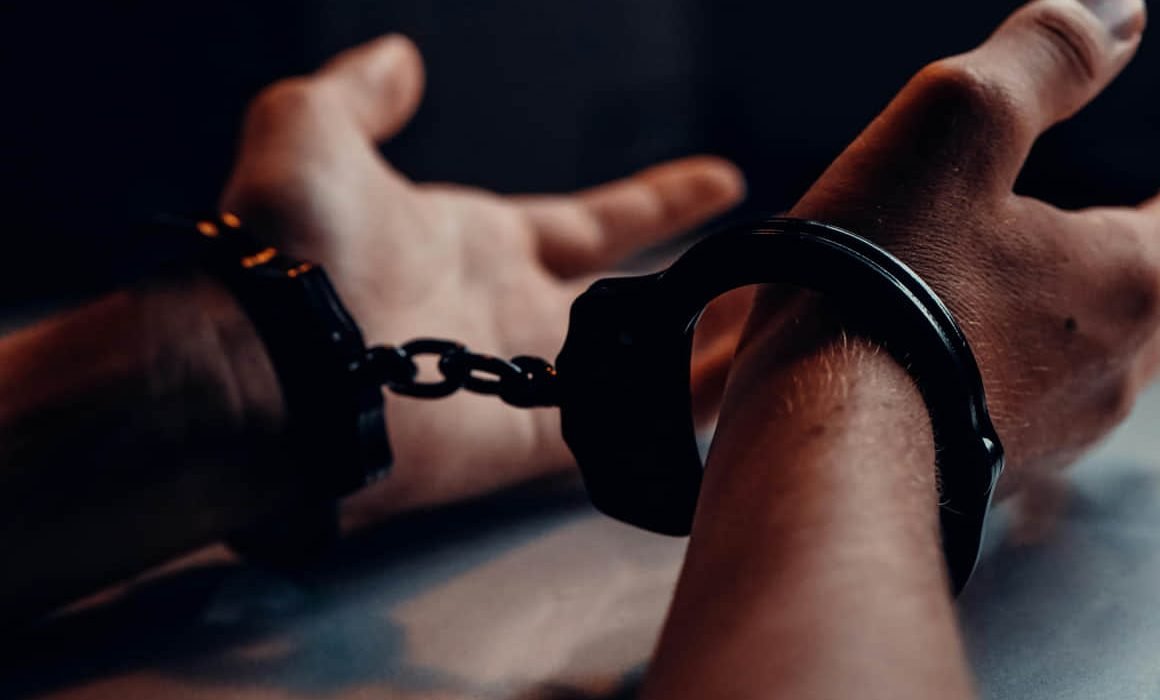 A man in a prison cell, representing detention in a travel agency fraud case in Mérida
