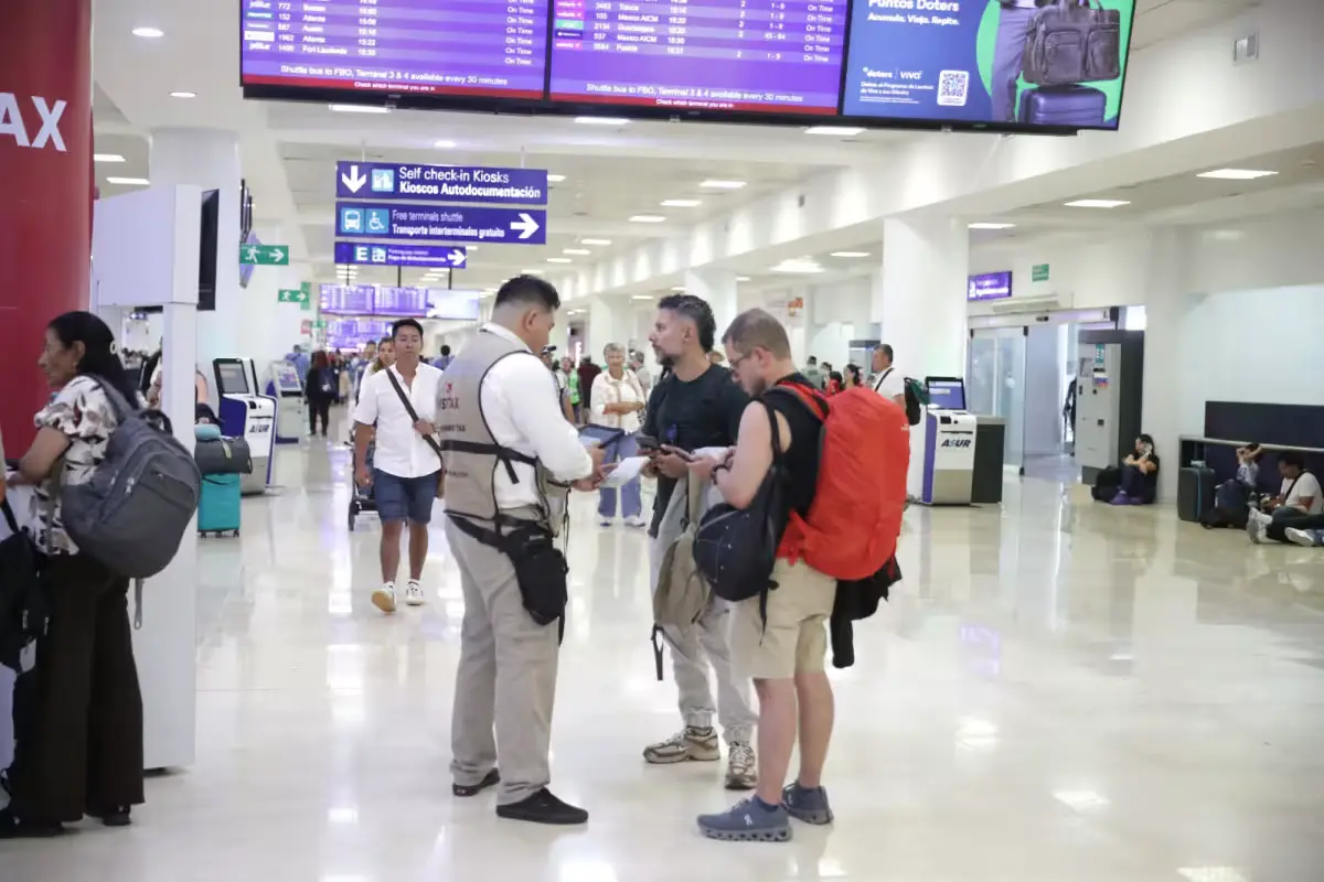Travelers pass by Visitax payment stations at Cancun International Airport