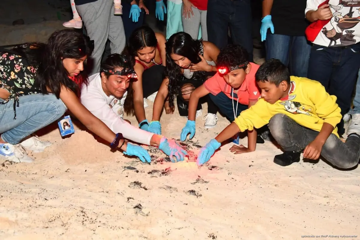 A group of children and adolescents with cancer walking along a Cozumel beach during the Ángeles Viajeros program