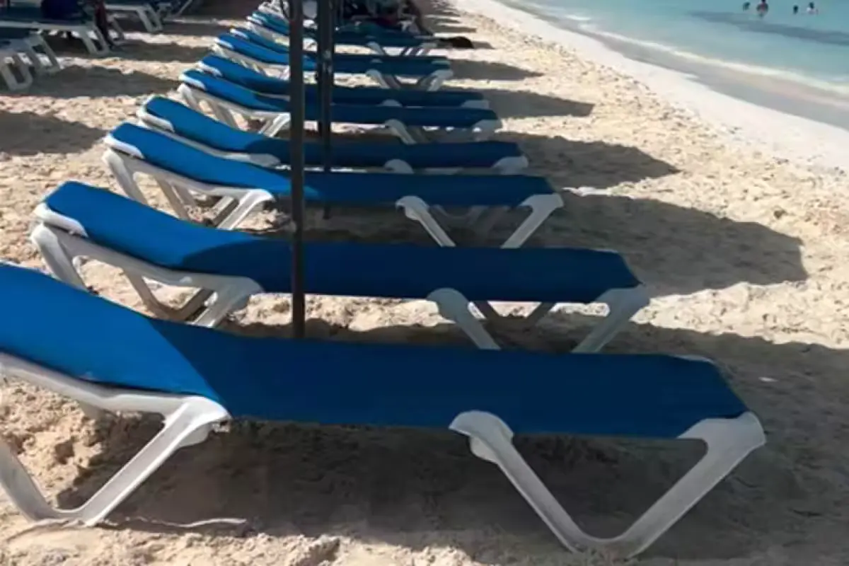Lounge chairs and umbrellas crowd the sand close to the water at Playa Norte on Isla Mujeres