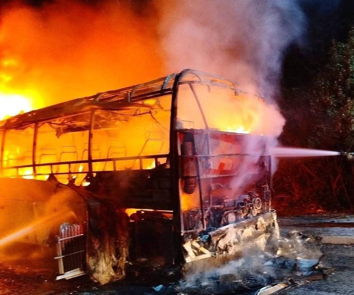 Firefighters extinguish a bus that was completely destroyed by fire on the Felipe Carrillo Puerto-Tulum highway in Quintana Roo.