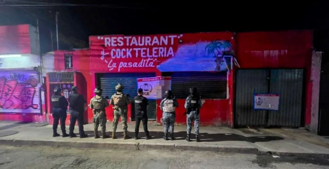 Police vehicles and officers outside a bar in Cancún, Quintana Roo, following a human trafficking raid