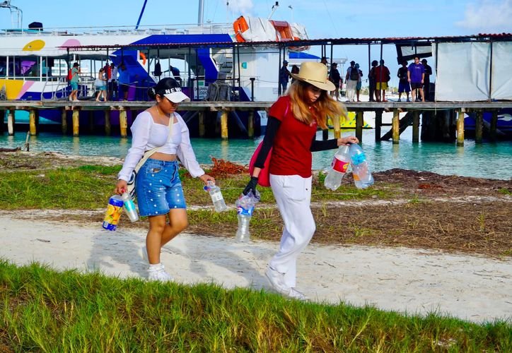 A beach cleaner collecting trash from a Cancun public beach in 2026