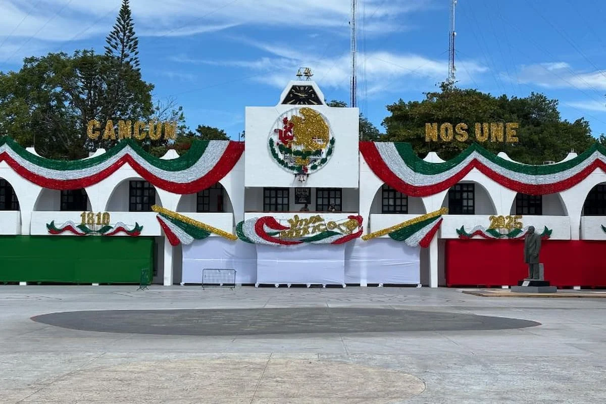 Crowds and police vehicles gathered near the Municipal Palace esplanade in Cancún ahead of the Grito de Independencia celebration