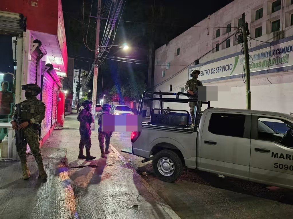 Police vehicles and officers outside a restaurant in downtown Cancún during a human trafficking investigation raid