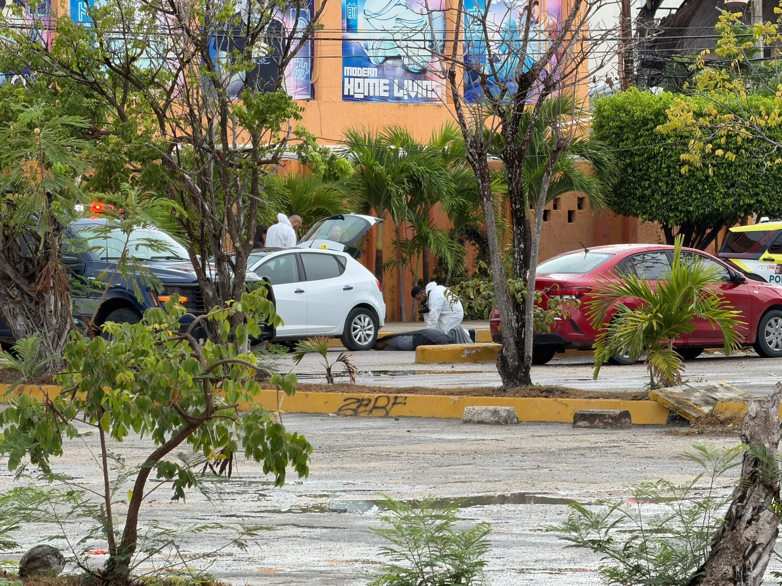 Police officers stand guard at the scene near Plaza Galerías in Cancún where a dentist was shot dead