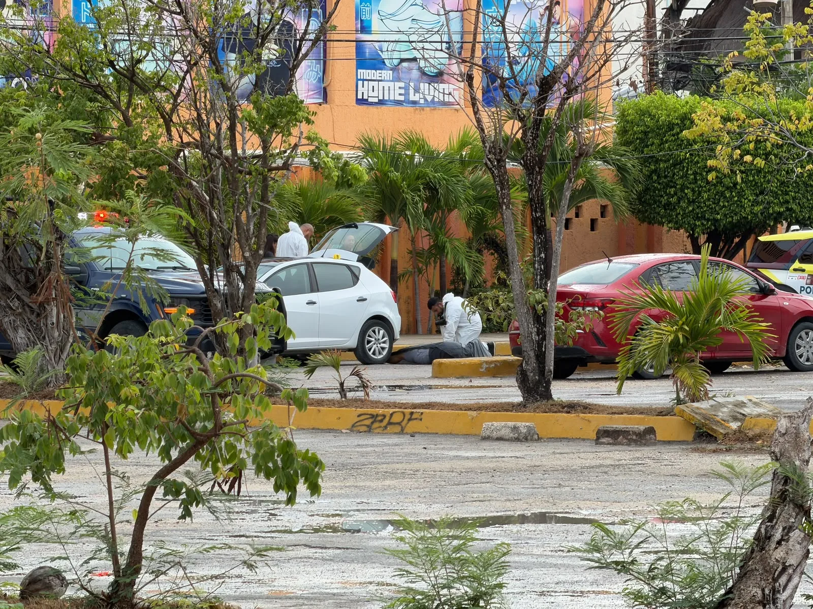 Police officers stand guard at the scene near Plaza Galerías in Cancún where a dentist was shot dead