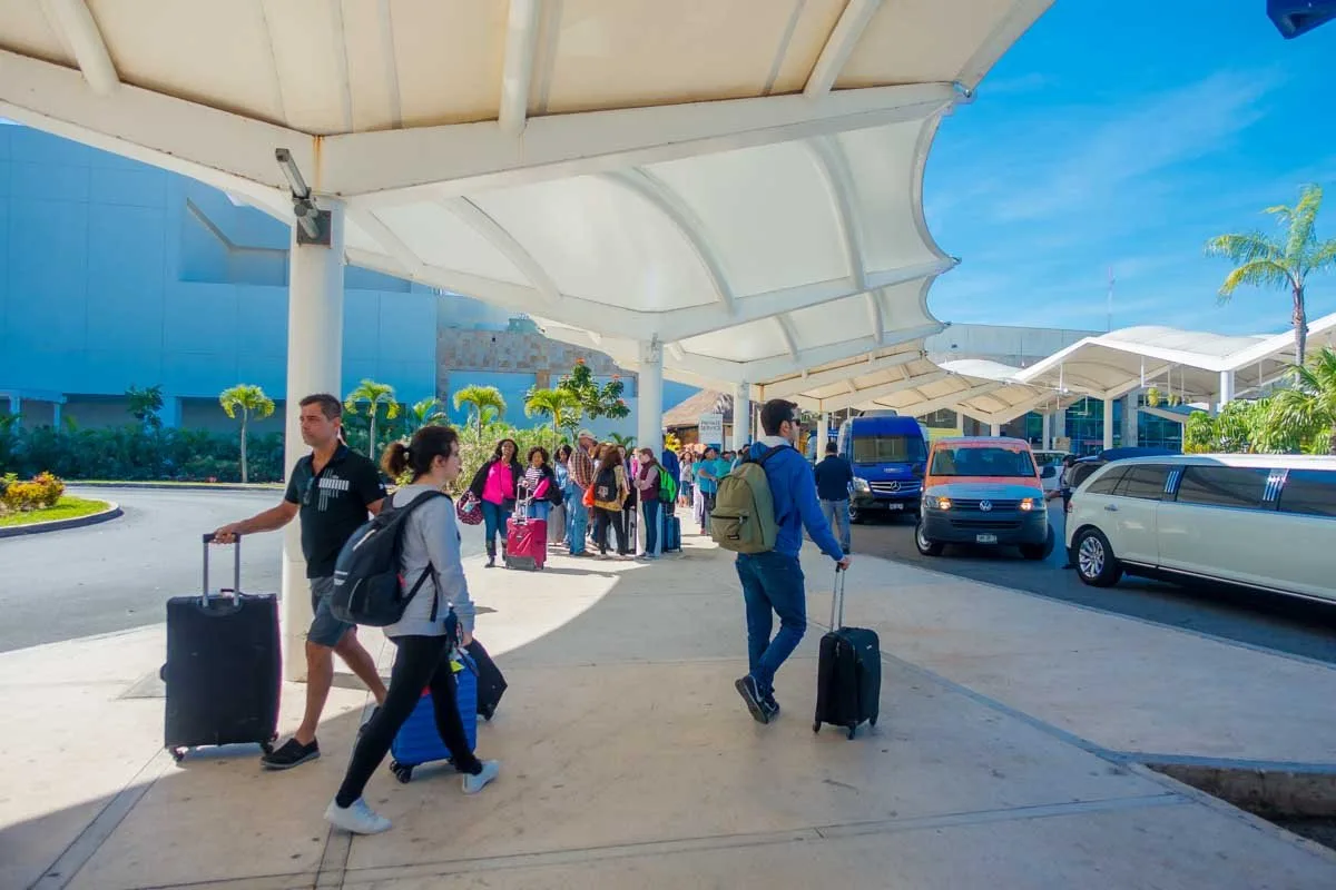 Tourist transport vans parked outside a terminal at Cancún International Airport