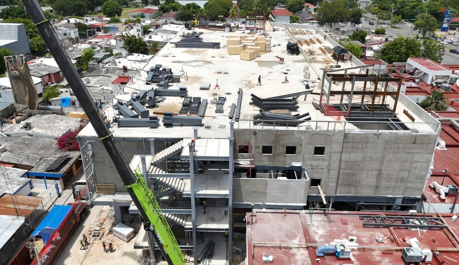 Construction workers in hard hats and safety vests working at a hotel renovation site in Quintana Roo, Mexico