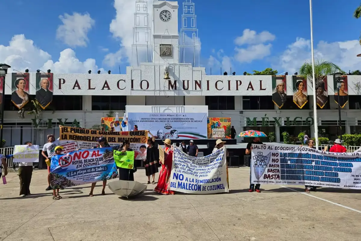 Residents and civic group members marching along a Cozumel street to protest the planned rehabilitation of the island's malecón