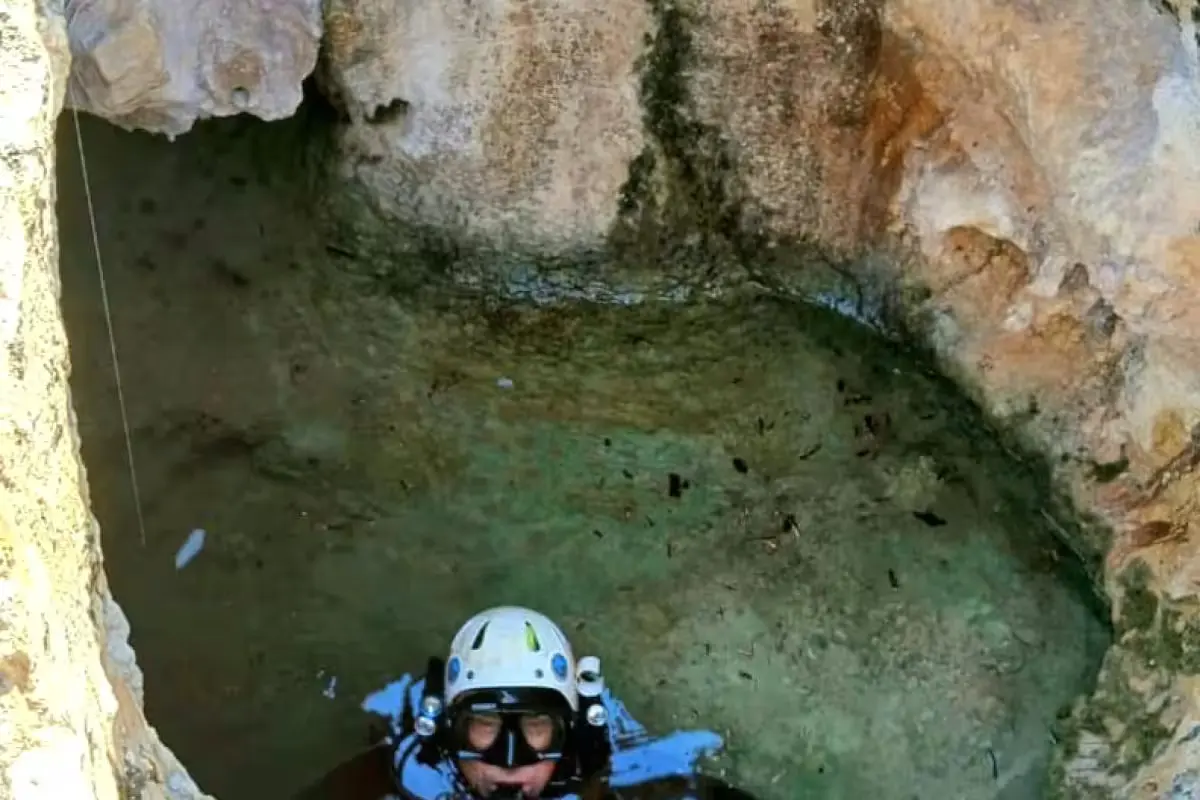 A cave diver enters a narrow flooded passage of Cueva Popotitos south of Cozumel using a safety line