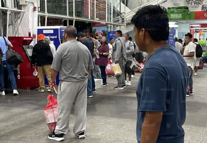 Mexican deportees wait with their belongings at the ADO bus terminal in Cancún after arriving from the United States.