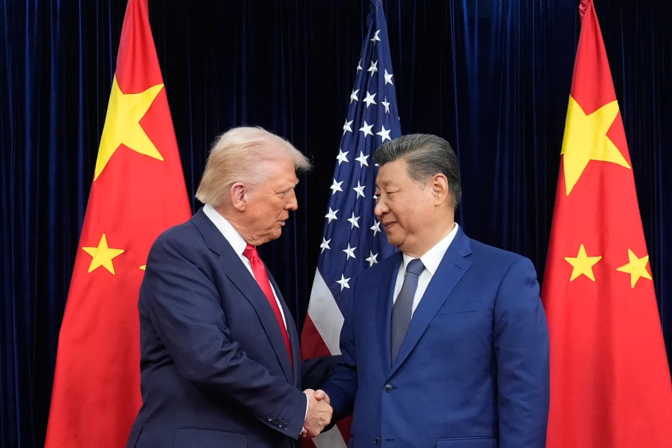 A handshake between two political leaders in front of Chinese and American flags.$# CAPTION