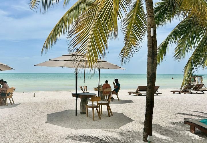 Hotels and turquoise water along the beach on Holbox Island during the summer tourism season
