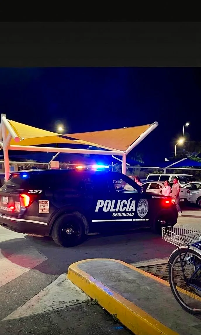 Police officers detain a man in a Walmart parking lot in Playa del Carmen after shoppers reported him trying to break into a parked car.