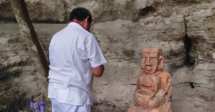 A sculpture of a Maya figure carrying a water jug standing inside the Sacalaca cenote in Jose Maria Morelos, Quintana Roo