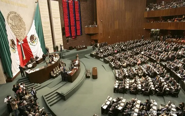 Legislators seated in a Mexican Chamber of Deputies committee room during debate on a constitutional reform restricting political rights of dual nationals
