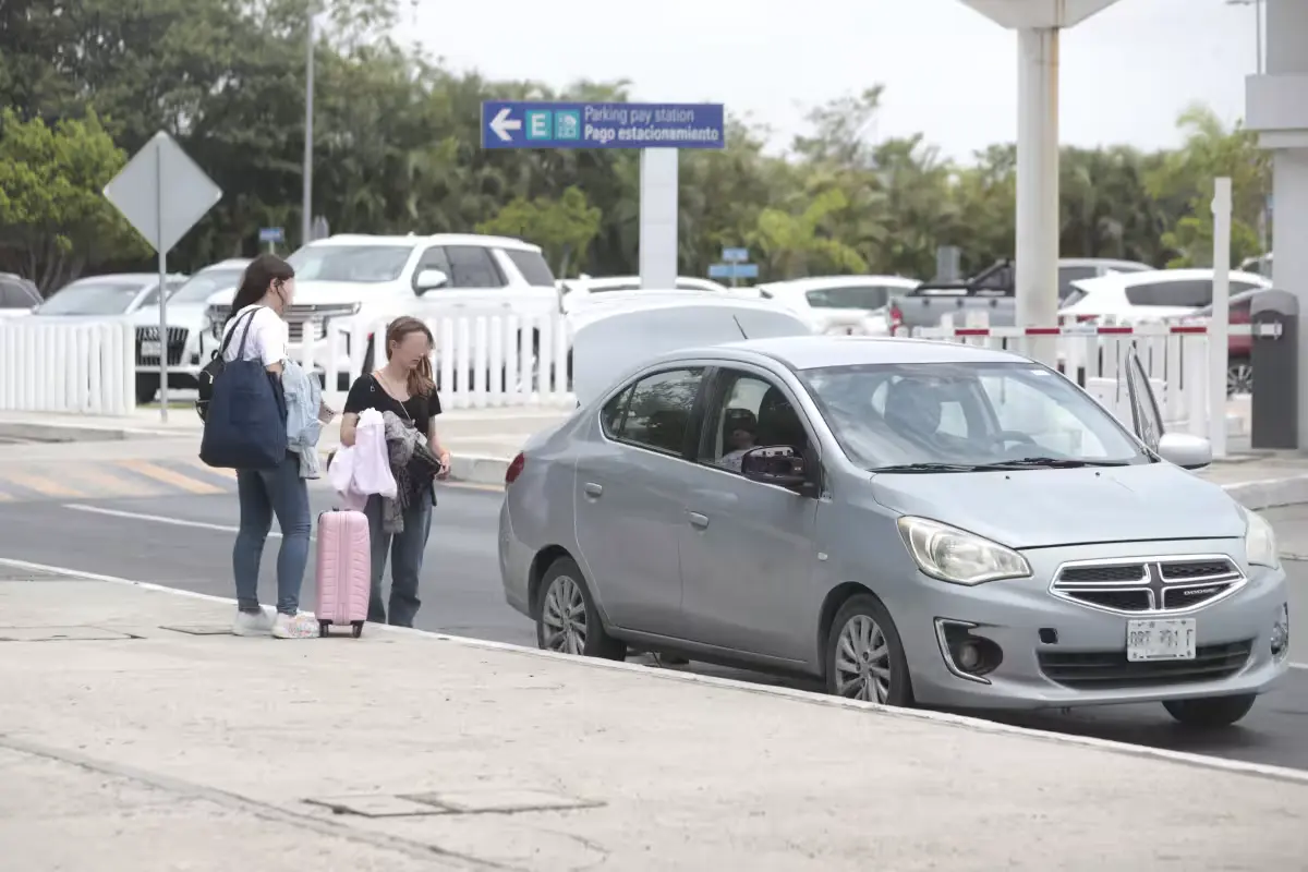 Official vehicles parked in a restricted zone outside the terminals at Cancún International Airport
