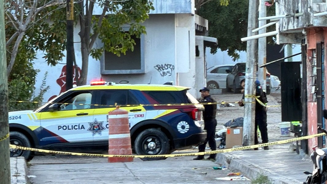 Municipal workers and police clear debris outside the abandoned General Hospital of Cancún after homeless residents were removed from the building