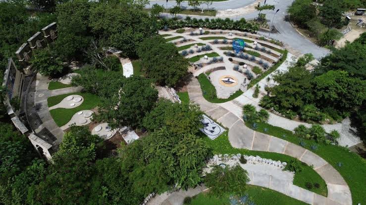Mountain bikers riding a dirt trail through green vegetation at Parque Cancún in Cancún, Quintana Roo