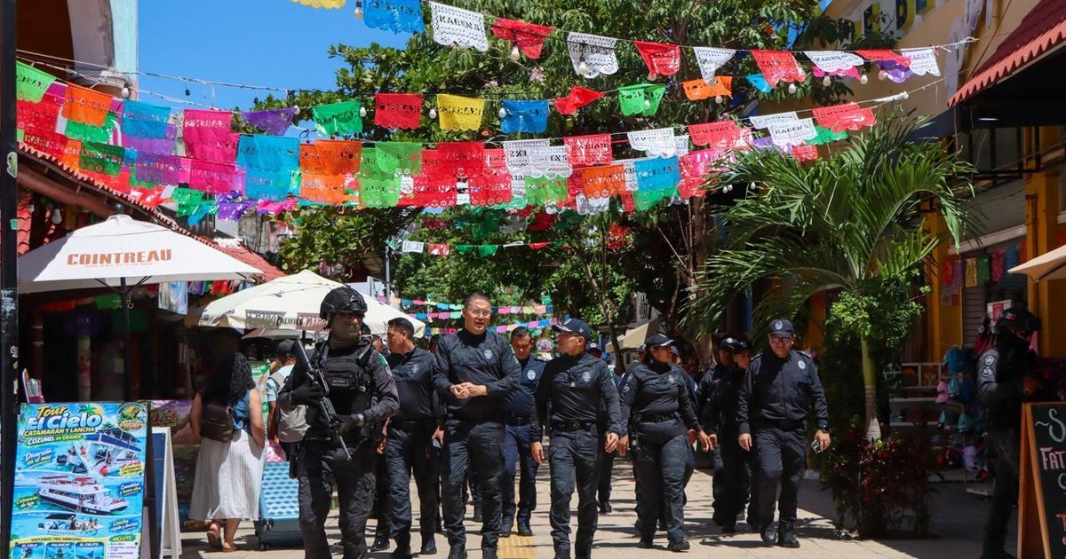 Police officers and security personnel standing along Quinta Avenida in Playa del Carmen during a security operation