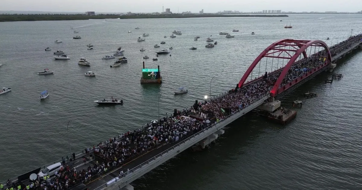 Families walking, running and cycling across the Nichupté Bridge in Cancún during the free Puenteando festival
