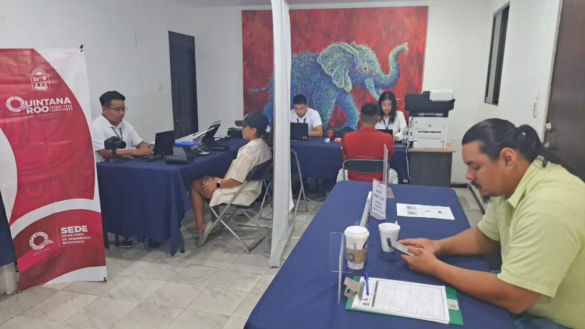 A taxpayer receives assistance at a temporary SAT service module inside the CANACO offices in Tulum.