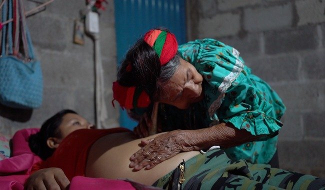 A traditional midwife attends to a pregnant woman inside a Mexican public hospital that combines ancestral practices with clinical medicine