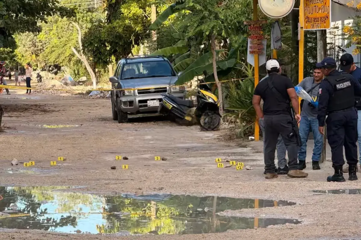 Police and forensic personnel cordon off the street corner in Tulum where a man was shot dead Friday morning