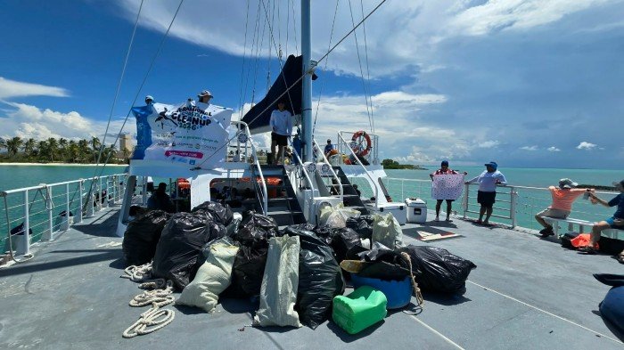 Volunteers collecting trash along the shore of Isla Contoy National Park in Quintana Roo, Mexico